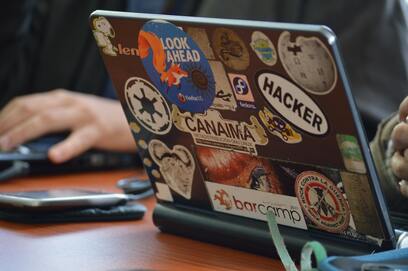 A laptop with many stickers on it's cover.