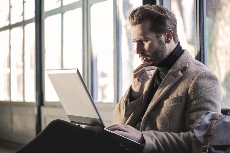 Man looking at computer confused about the difference between a sticker and a decal.